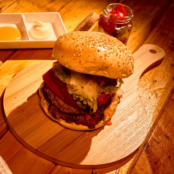 Hamburguesa doble con queso sobre tabla de madera