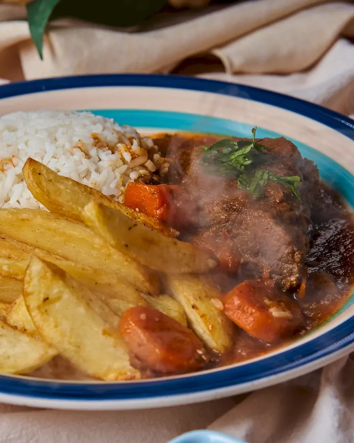 Carne al jugo humeante con papas fritas y arroz