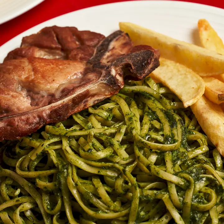 Chuleta de cerdo con tallarines verdes y papas fritas