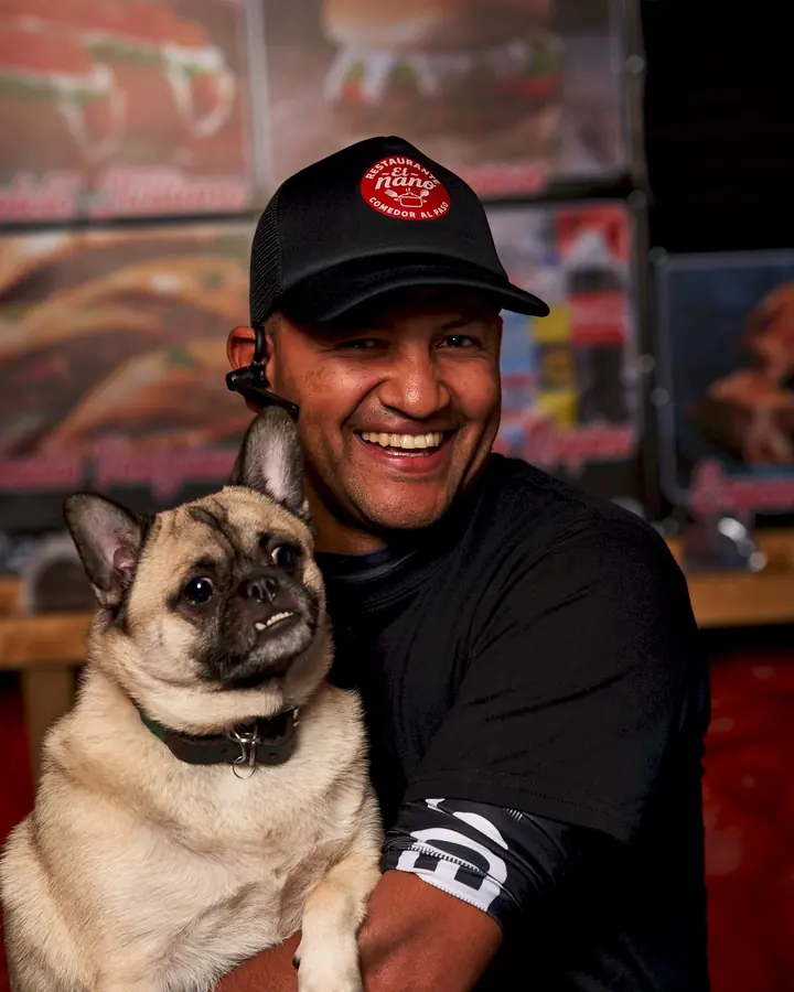Integrante del equipo de El Ñaño con un perrito pug en brazos
